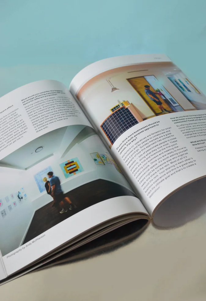 An open magazine displaying images of people viewing artwork in a gallery or museum.