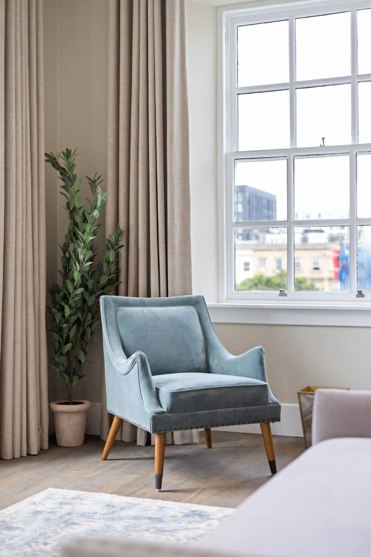 Bedroom corner with blue velvet armchair and sash window at West Regent Street, Glasgow, by SANNA Design Studio