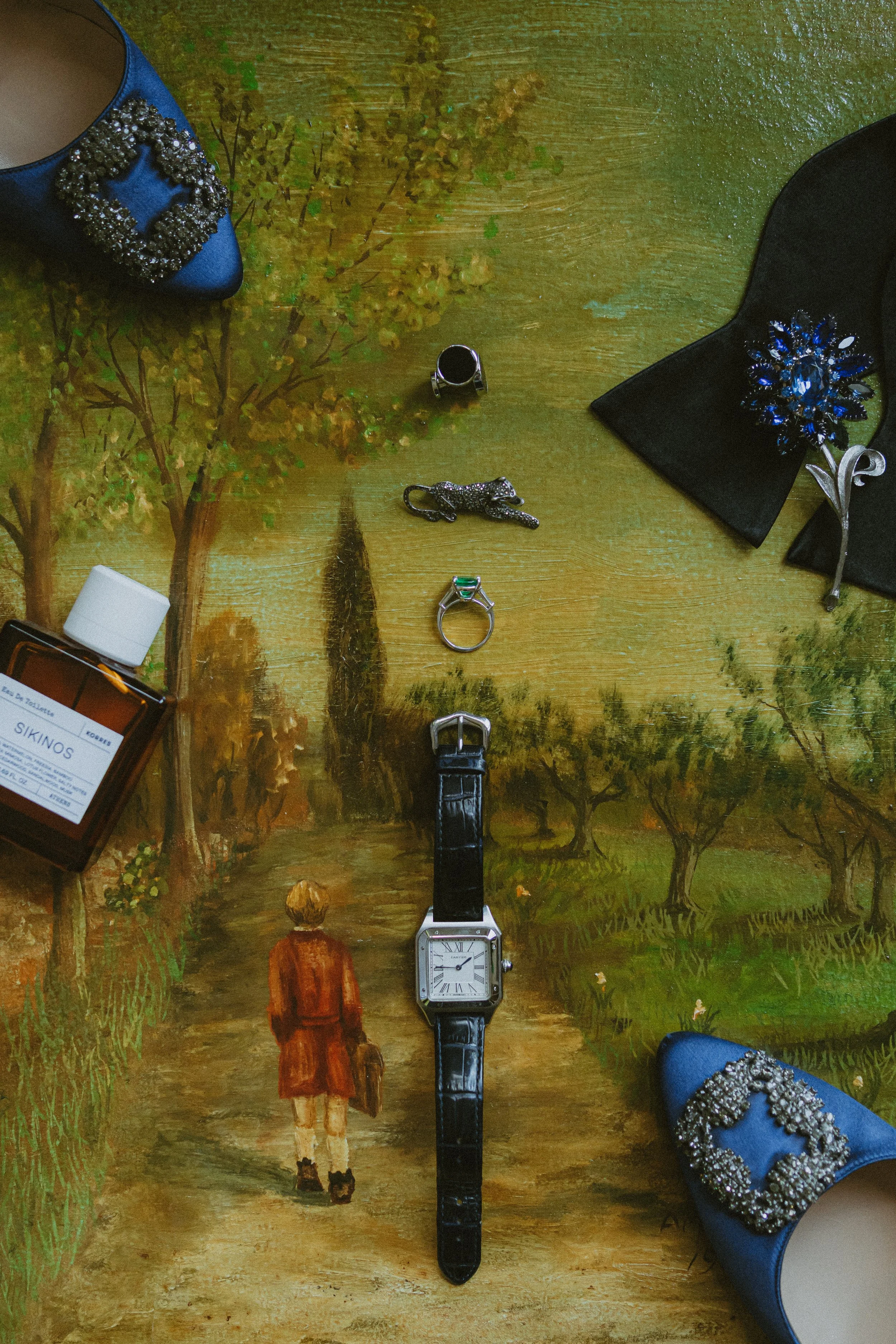 Objects on a wooden table with an illustration of a woman walking down a path.
