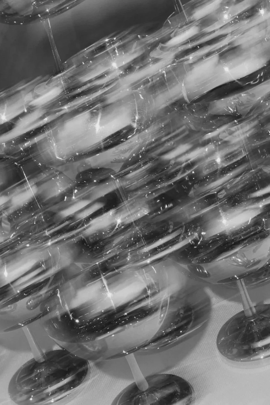 Multiple rows of wine glasses filled with wine, arranged closely together on a table.