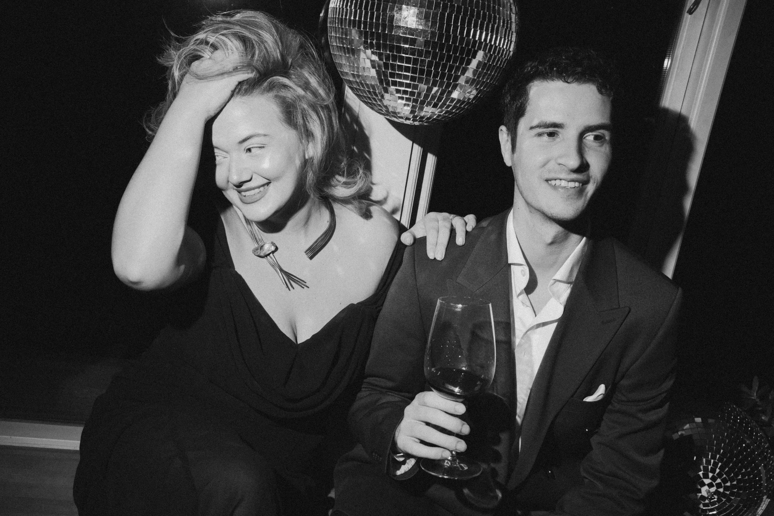 Catalina and Andrei in a black and white photographs with a retro disco globe behind them