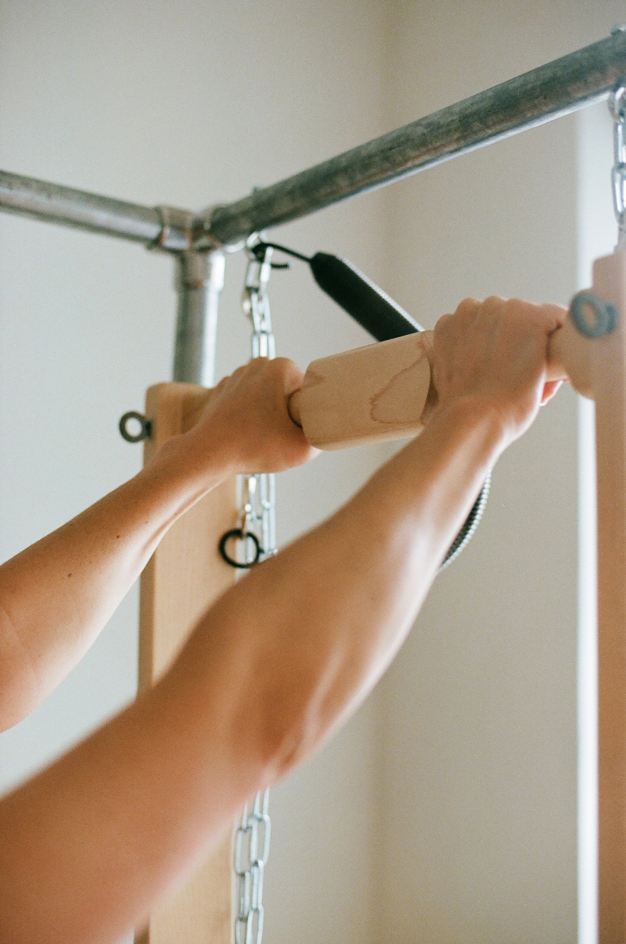Hands working with traditional Pilates apparatus