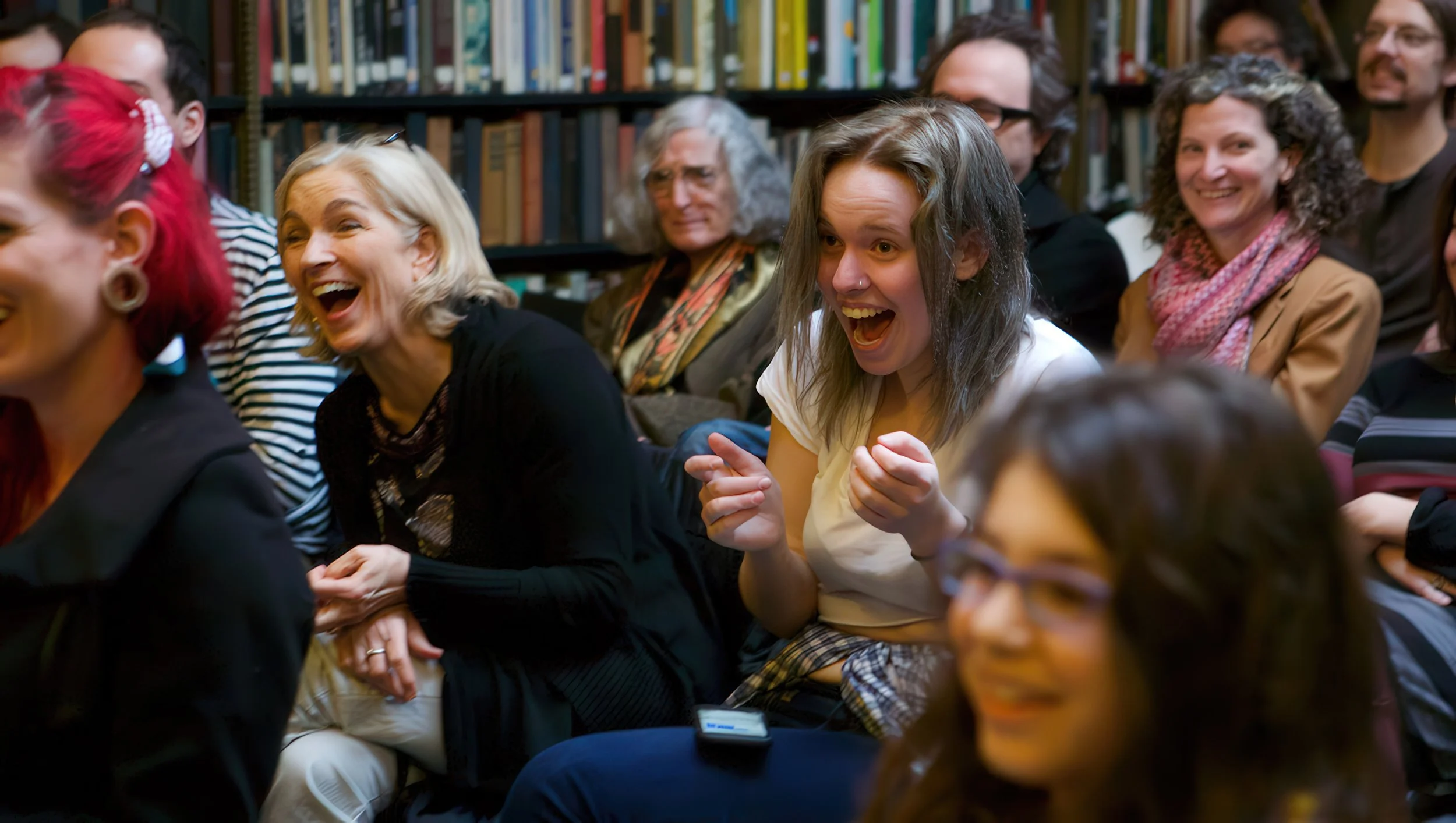 People in a library laughing and enjoying a group event