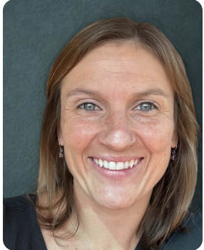 Close-up of a smiling woman with shoulder-length light brown hair and blue eyes against a solid teal background.