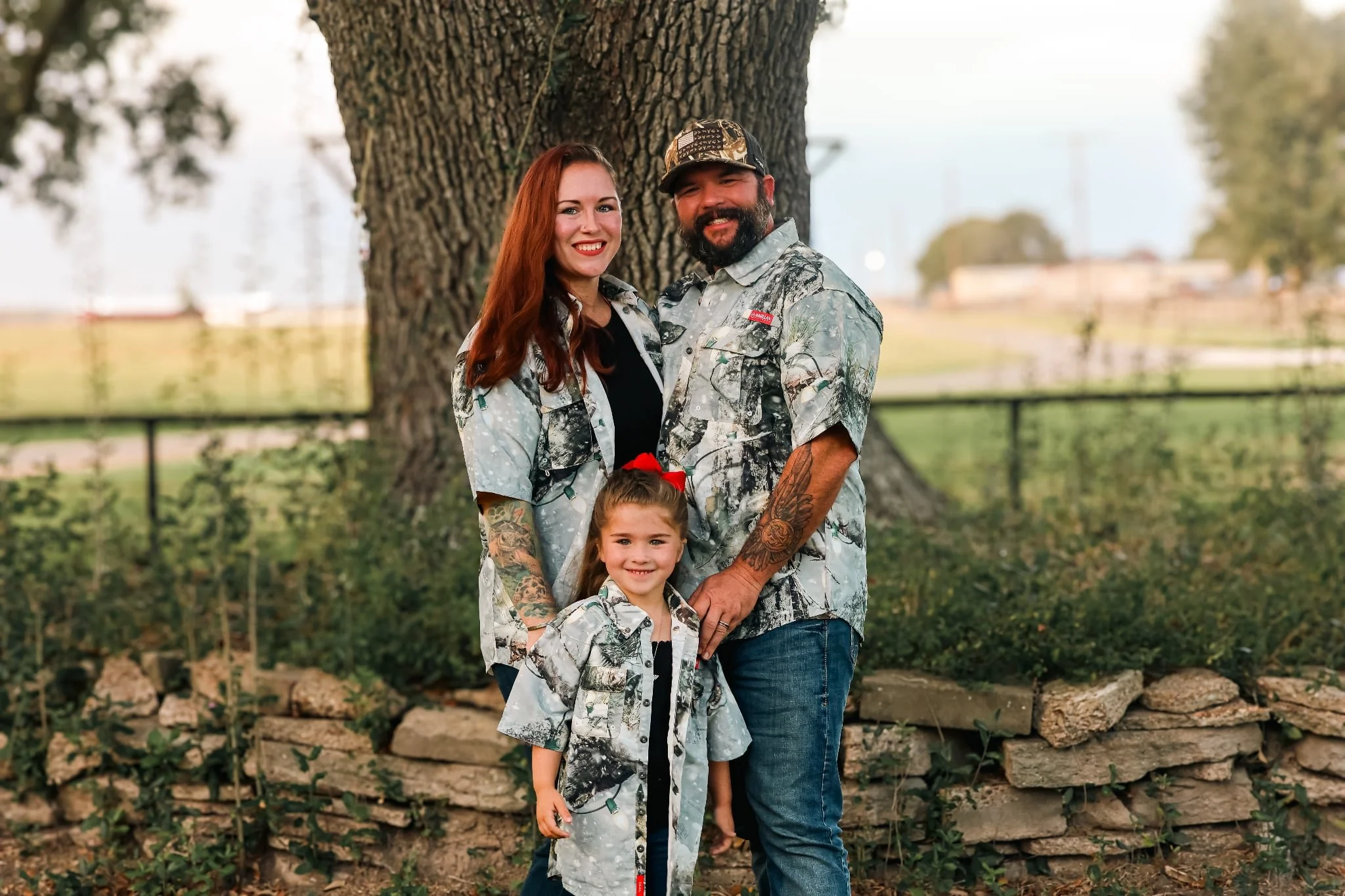 Family portrait of the Kromschroeder family, creators of Driftwood Dreams Publishing, standing together outdoors beneath a large tree
