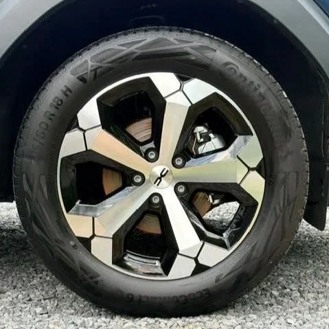 Close-up van een autoband en wiel met een uniek, geometrisch design.