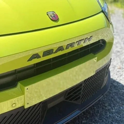 Voorzijde van een felgele Abarth auto met logo en grille met keramische coating.