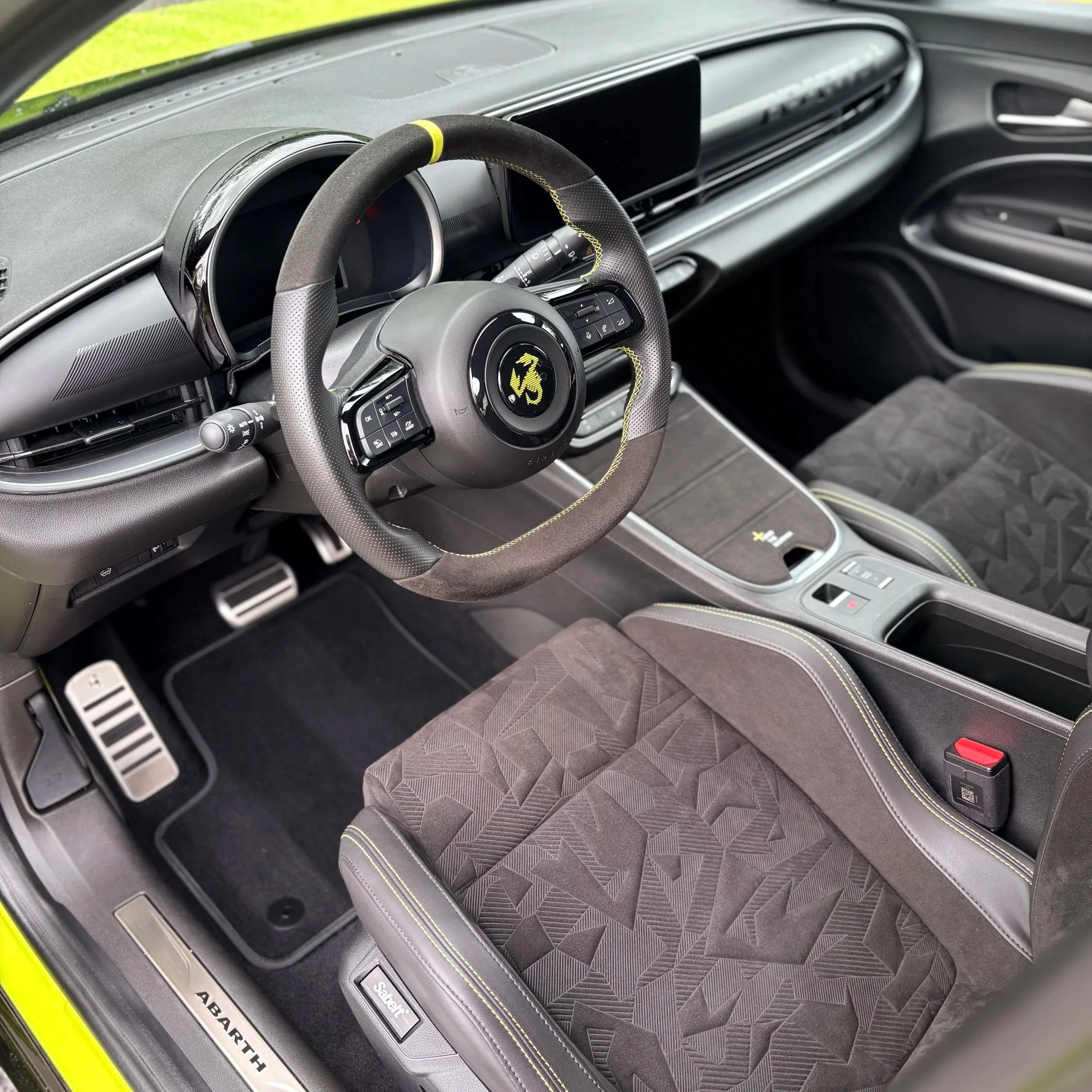 Interieur van een auto, inclusief stuurwiel en dashboard.