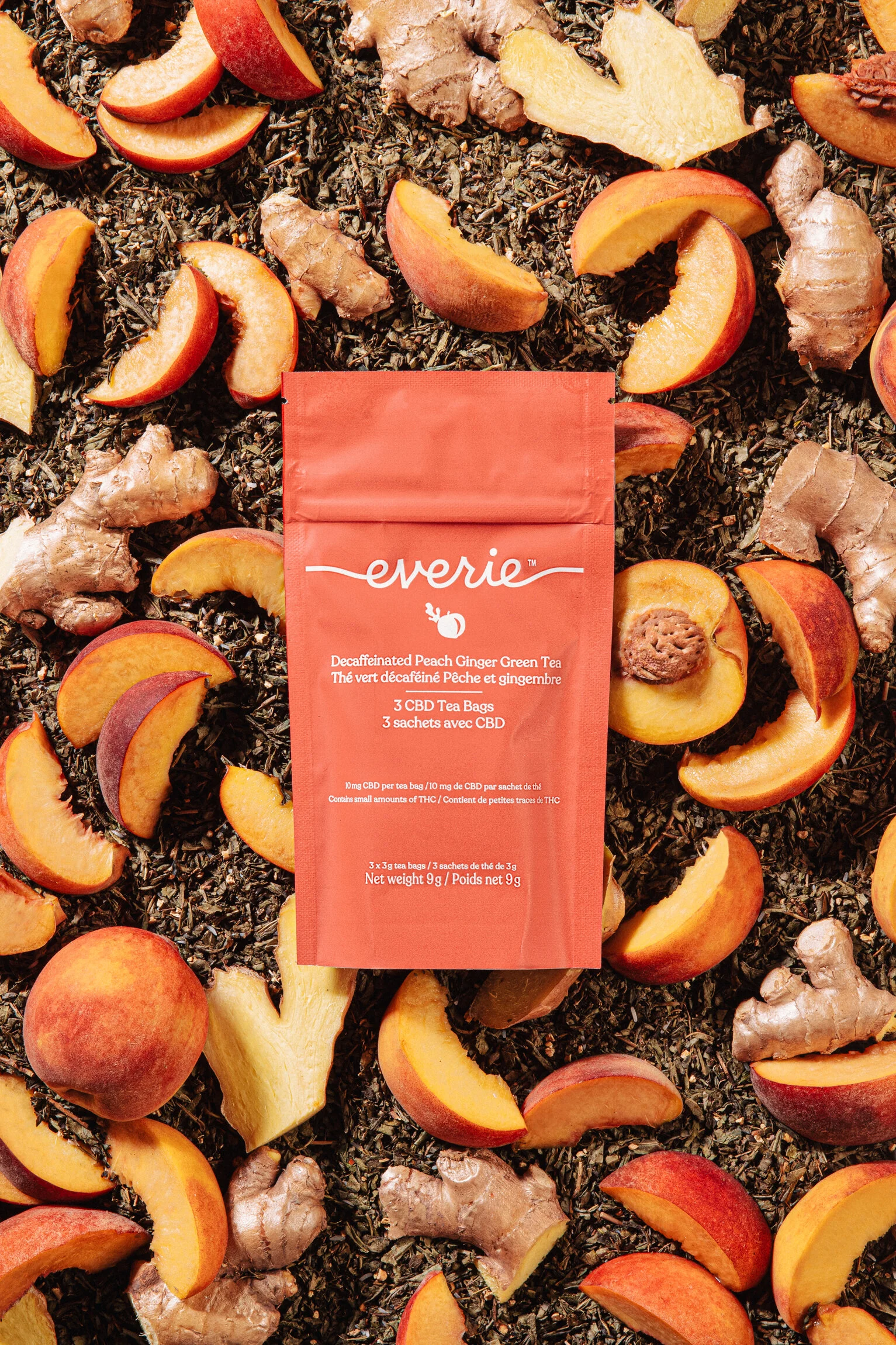  A packet of tea sits on a bed of food flavour cues, peach, ginger and tea leaves. Product photography by El Keegan, Dublin, Ireland.  