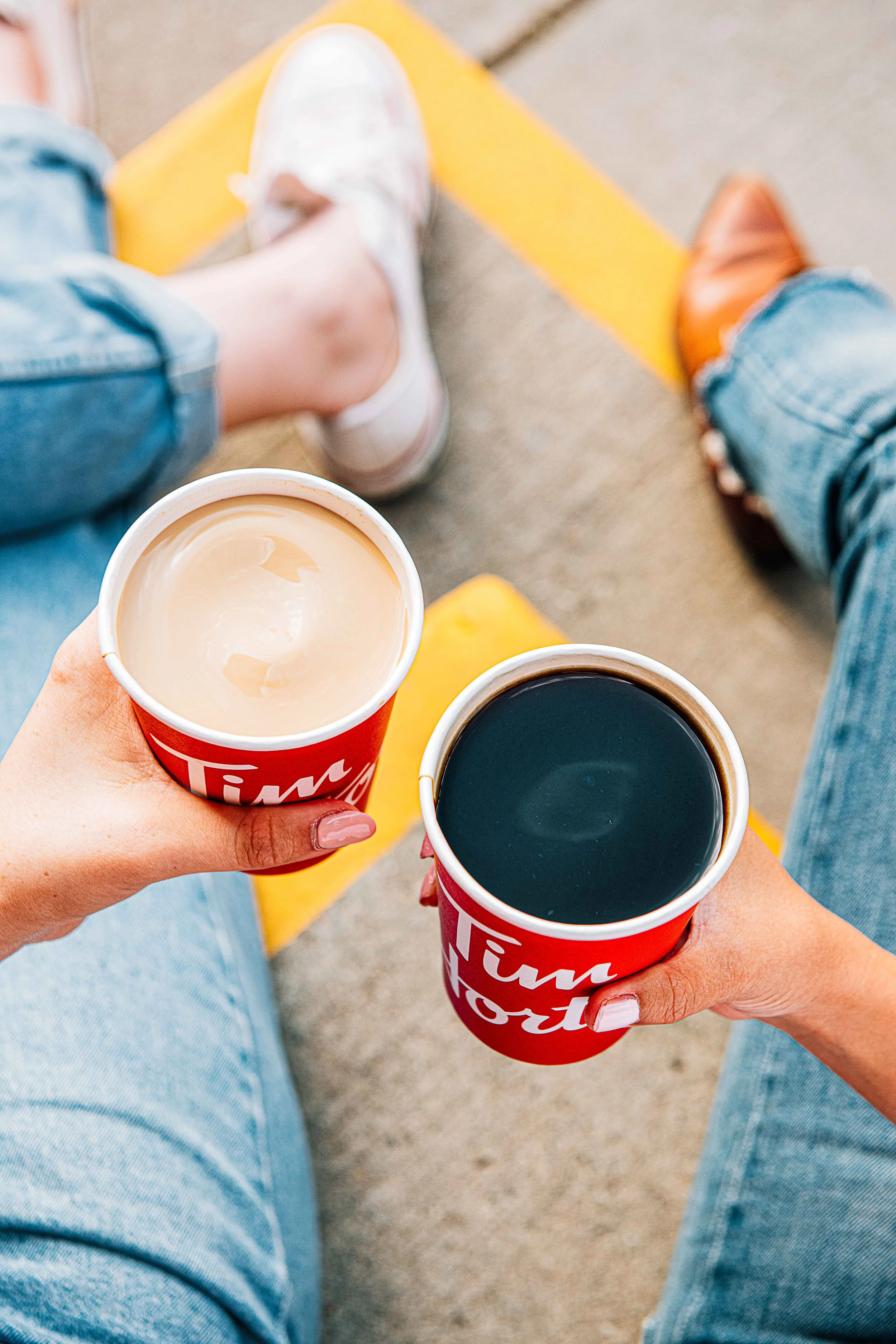  Two women hold two hot drinks together for national coffee day. Photographed by Dublin Lifestyle Photographer, El Keegan for Tim Hortons.  