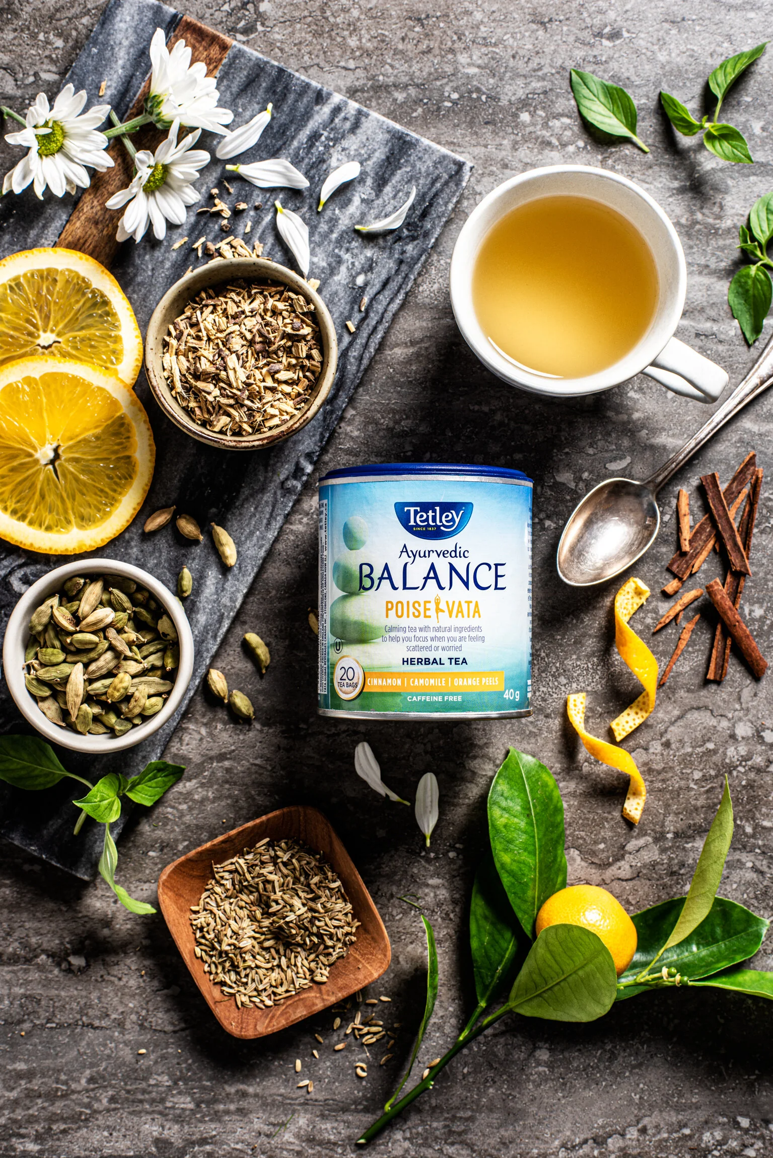  An overhead photo of Tetley tea surrounded by sliced lemon, spices, seeds and a cup of tea. Commercial Photography by El Keegan.  