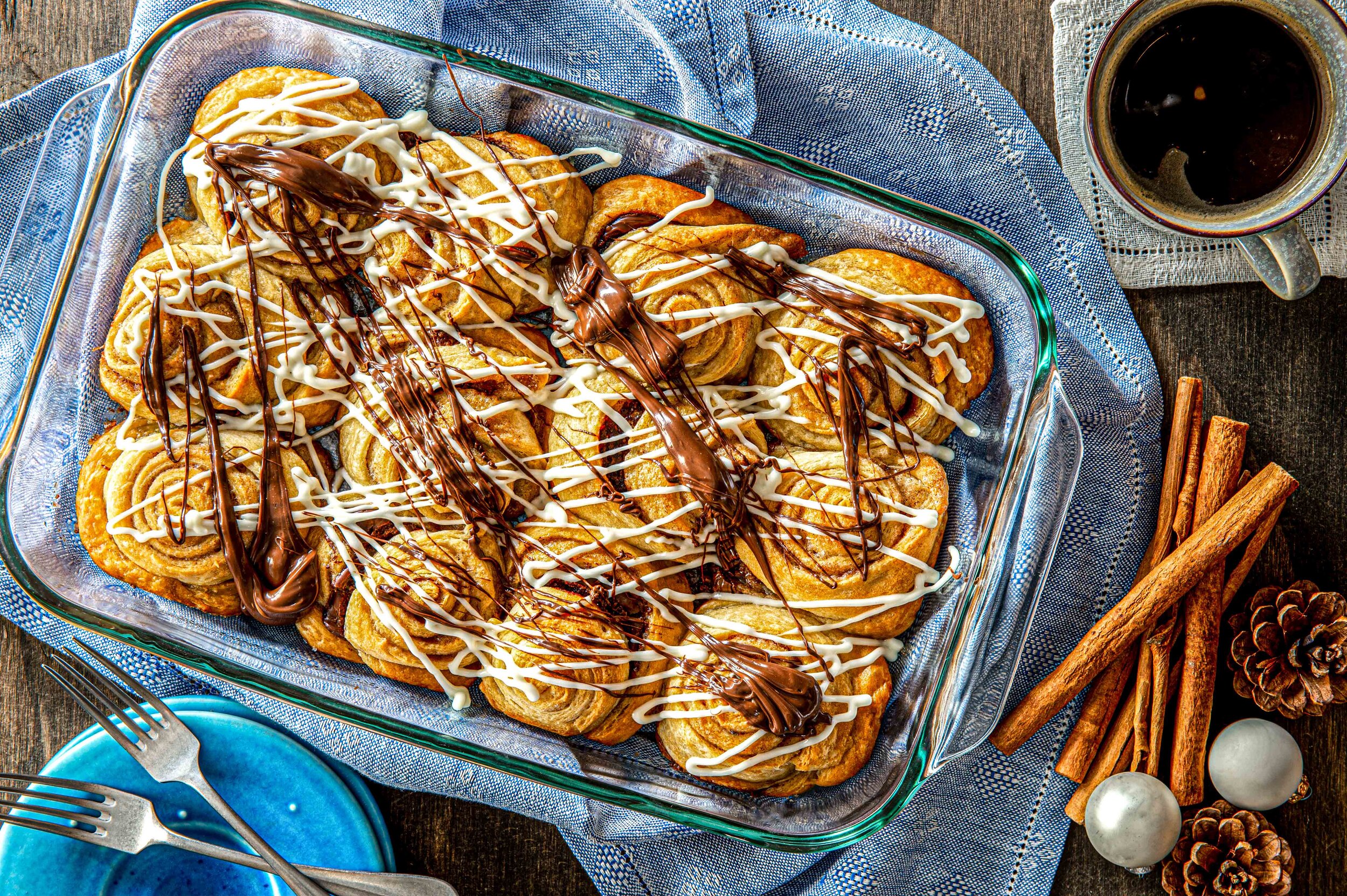  Cinnamon buns drizzled in chocolate and vanilla icing ready to be eaten. Photographed by El Keegan.  