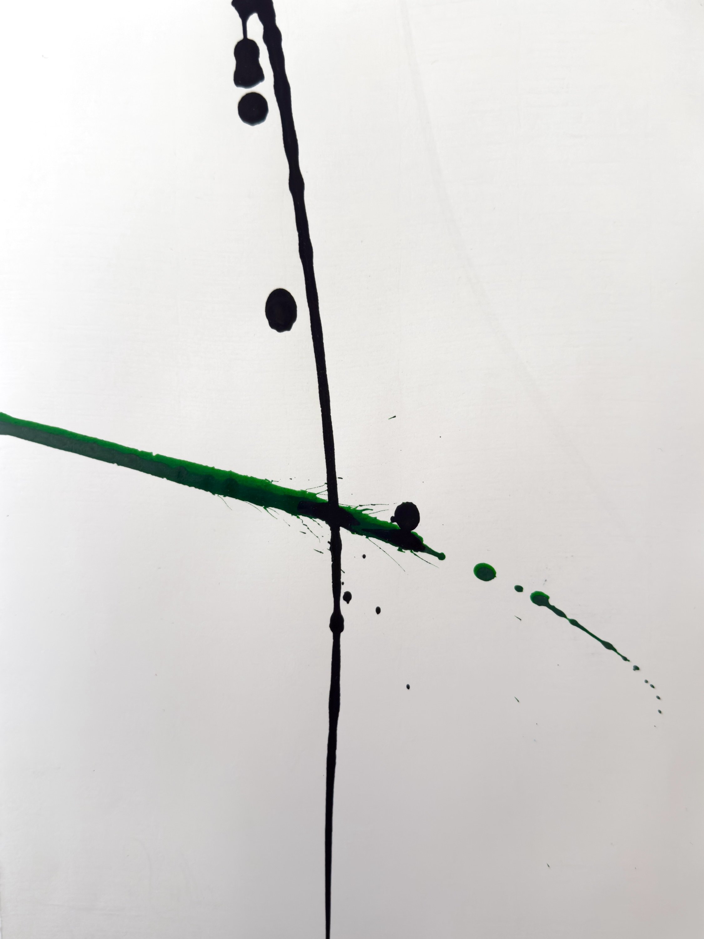 Abstract painting with black and green ink splatters on white paper, featuring a vertical black line and scattered ink droplets.