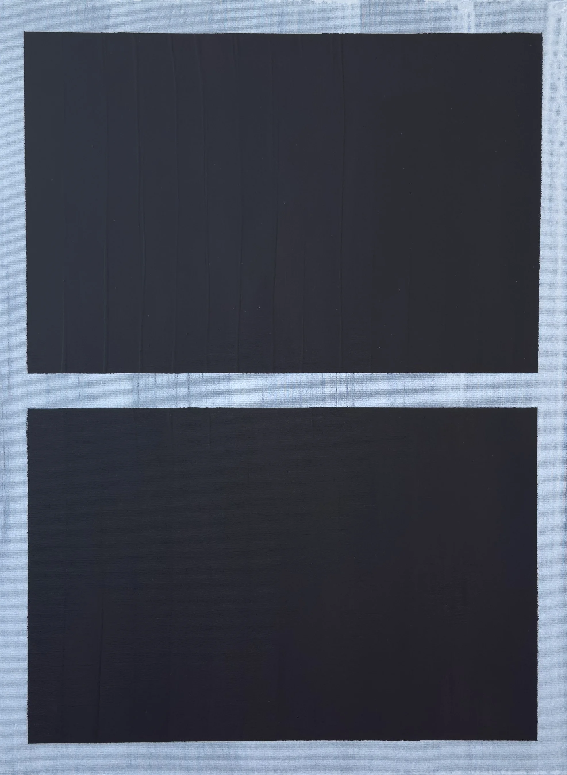 Two black rectangular solar panels placed horizontally on a light-colored surface.