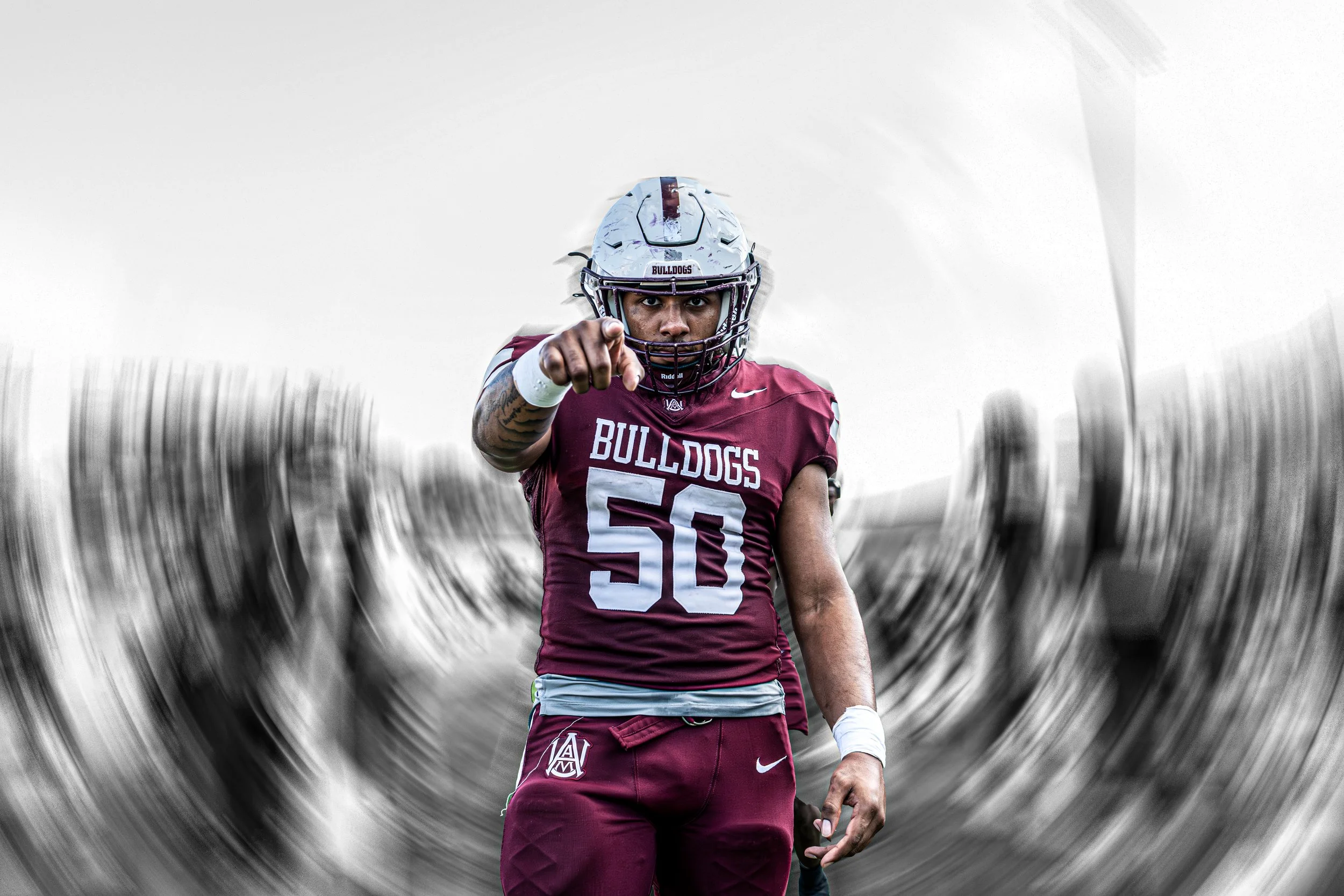 An American football player wearing a maroon uniform with the word 'Bulldogs' and the number 50, pointing directly at the camera while wearing a white helmet with a maroon stripe.