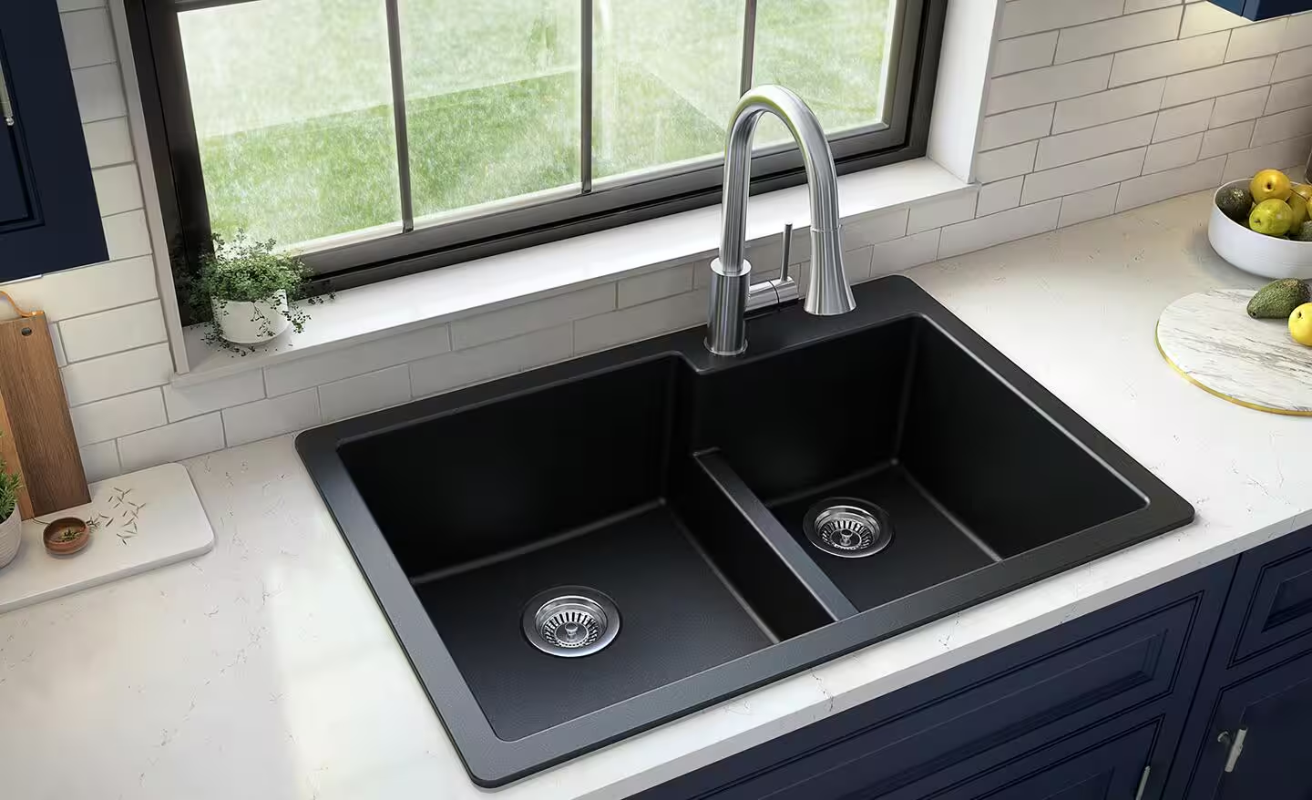 black double-basin kitchen sink with a high-arc faucet on a white countertop under a window. There is a bowl of apples and a marble cutting board with avocados and apples on it, nearby.