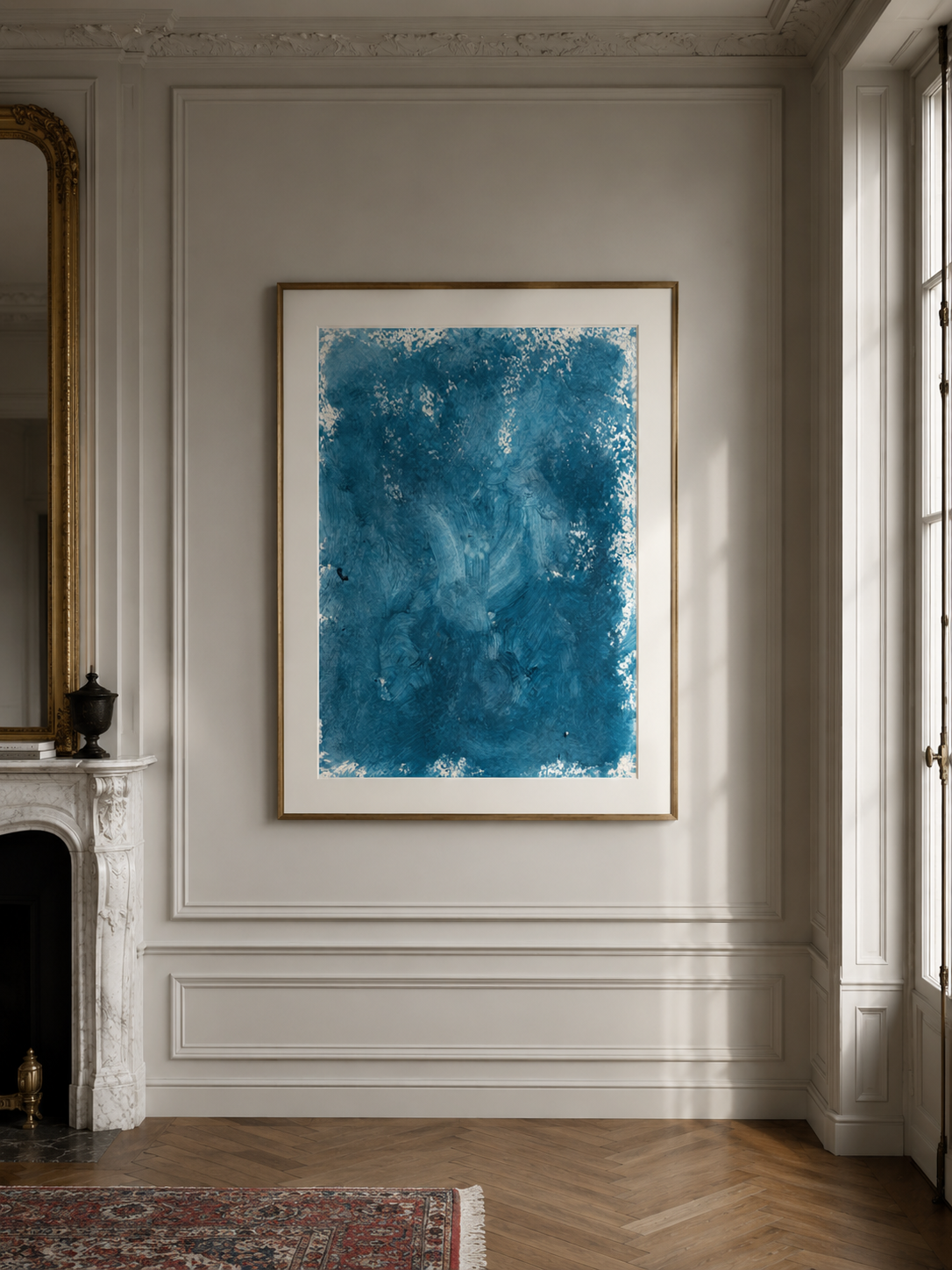 Cuadro abstracto en tonos azules colgado en una pared blanca en una sala elegante con molduras y una chimenea de mármol.