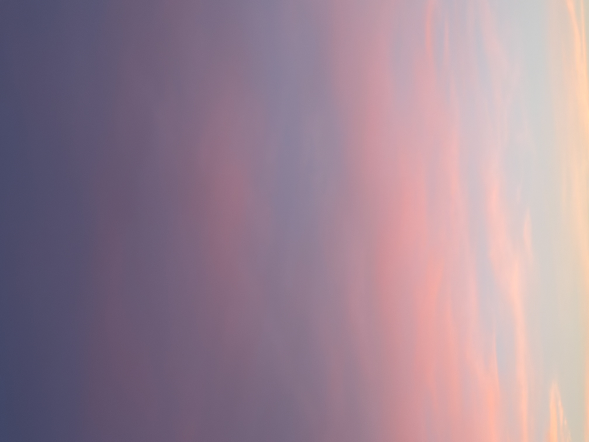 Un cielo con tonos pastel de azul, rosa y naranja durante el atardecer