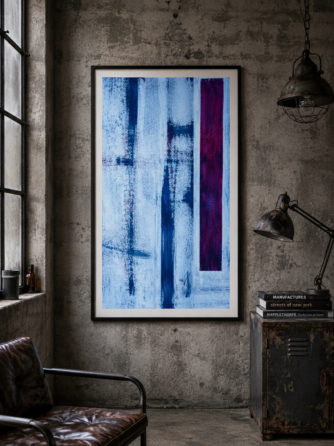 Pintura abstracta de líneas verticales en tonos azules y morados en un marco negro colgado en una pared de cemento en un estilo industrial con lámparas de hierro y una silla de cuero en una habitación moderna.