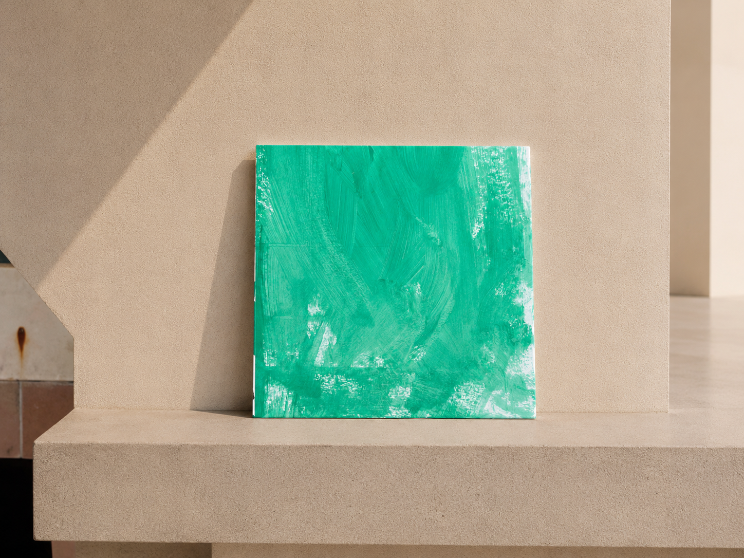 Cuadro abstracto verde con trazos en una pared beige