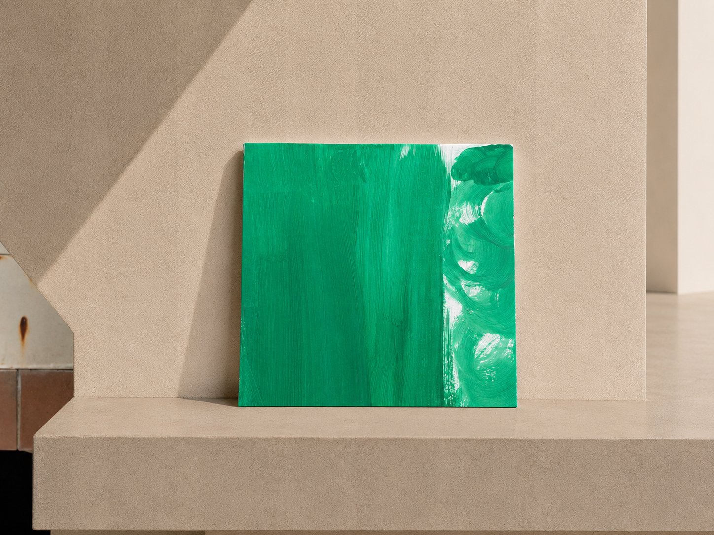 Cuadro de arte abstracto con tonos de verde, colocado sobre un soporte de color beige.