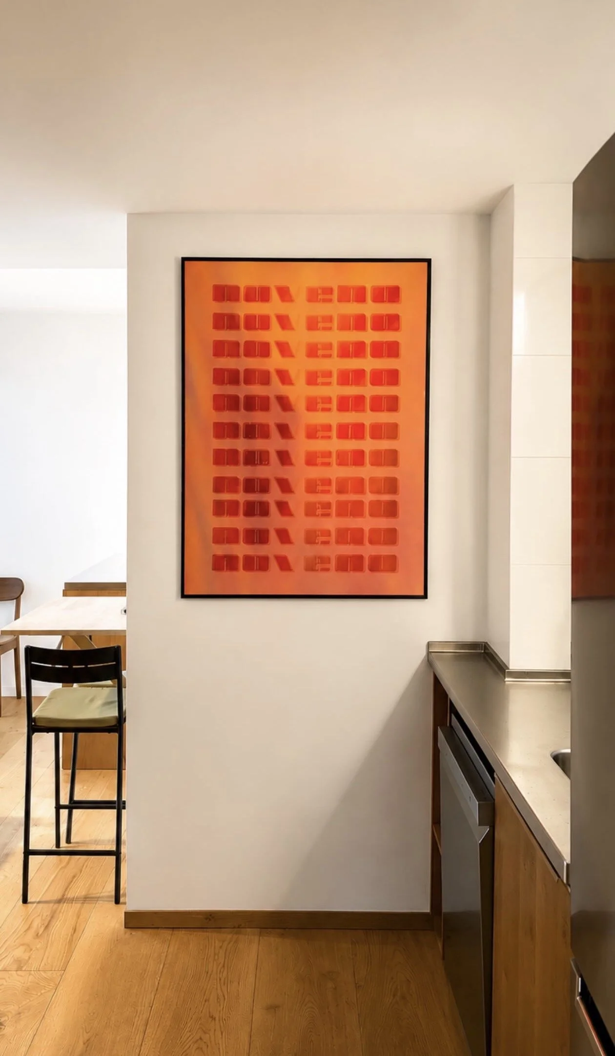 Pintura en la pared con repeticiones de la palabra 'NUEVO' en diferentes generaciones con fondo naranja y letras rojas.