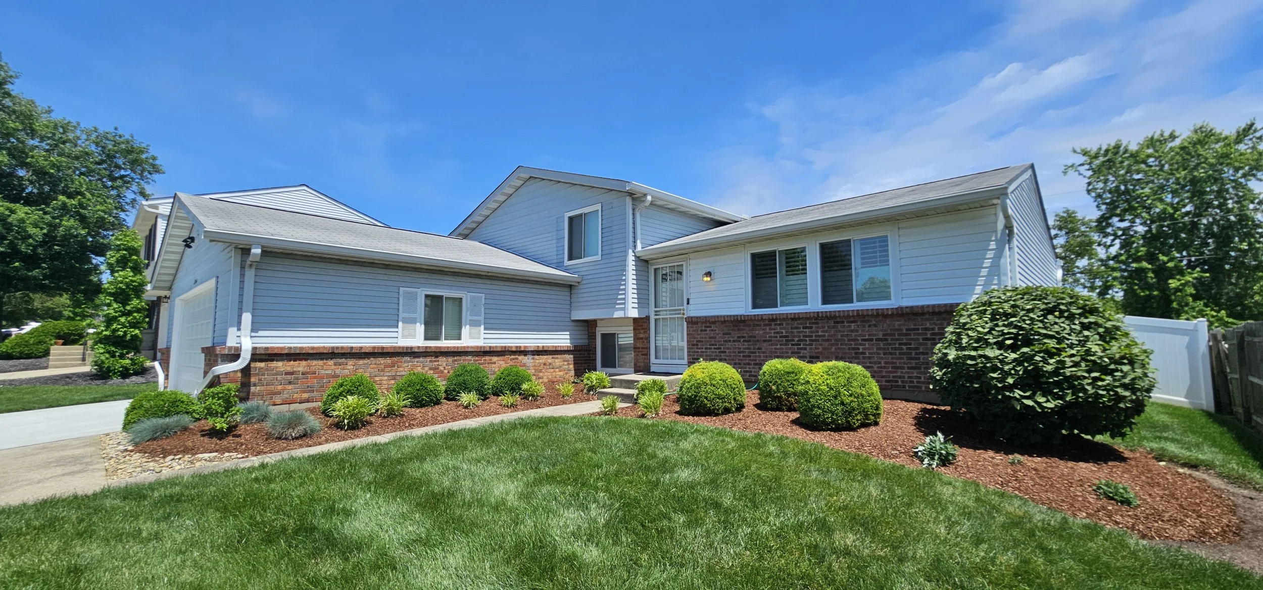 Fresh mulch, clean bed edges, and maintained foundation shrubs at a residential property.