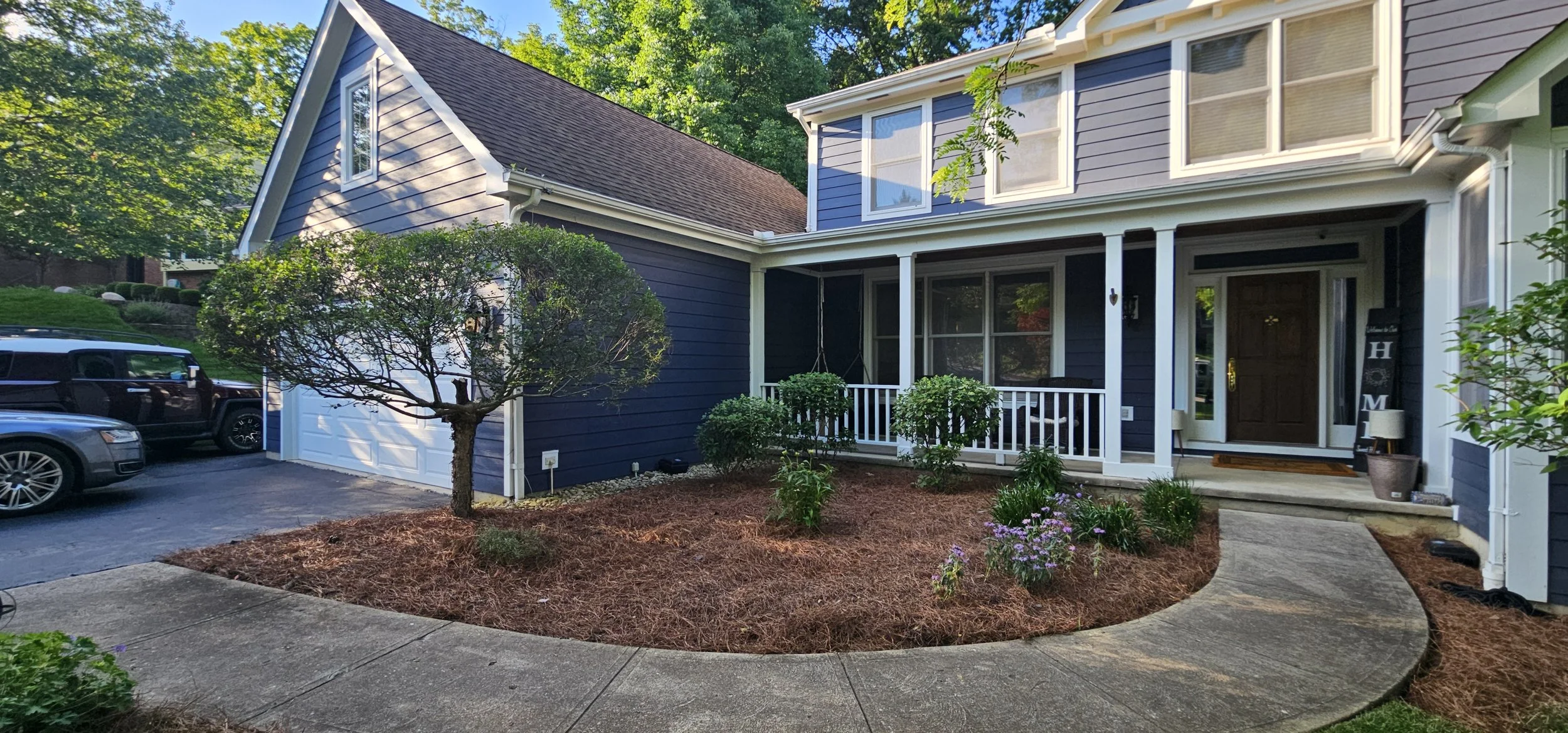 Front landscape beds refreshed with mulch, cleaned bed edges, and maintained foundation shrubs.