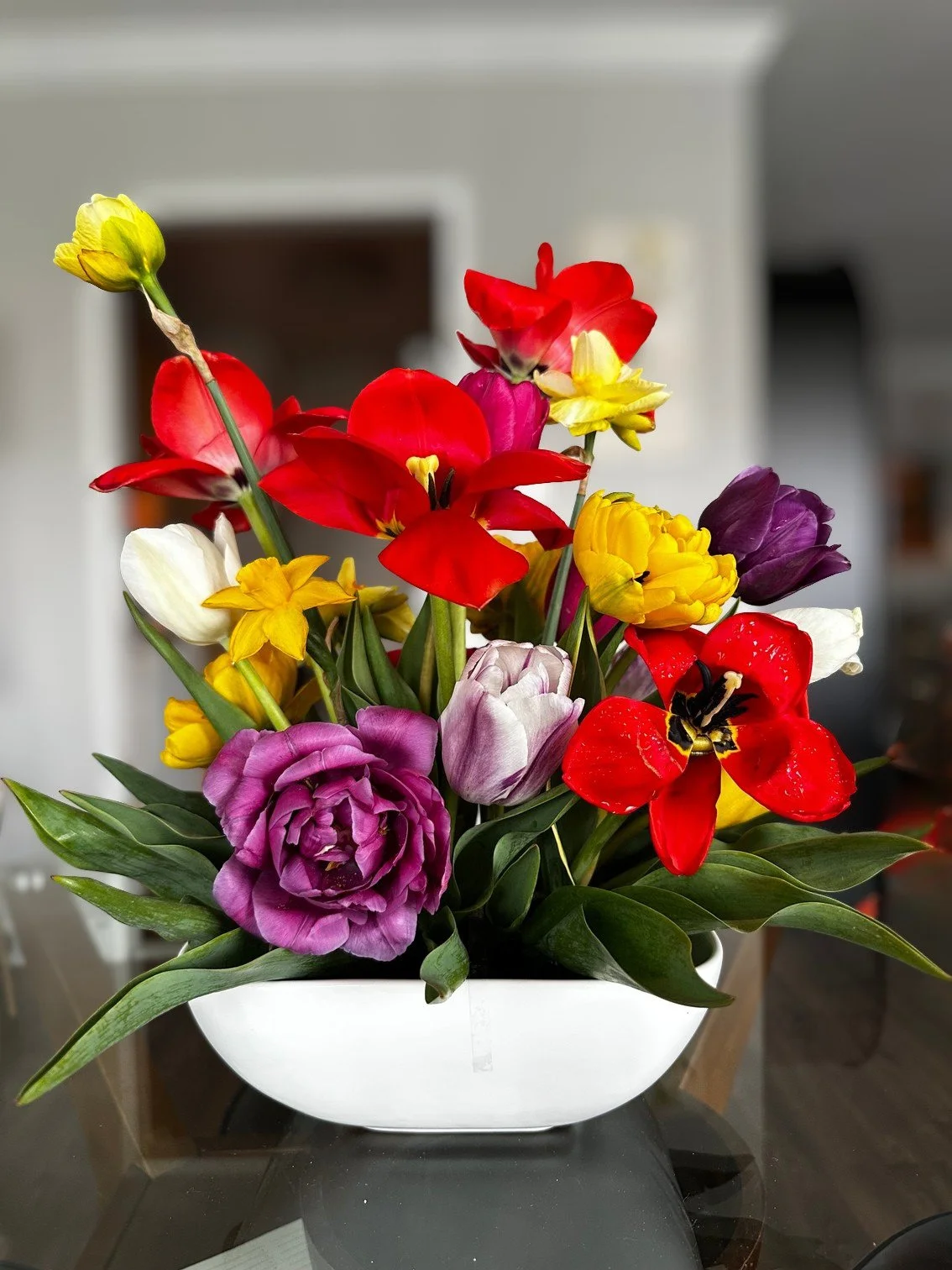 A unique, colorful floral arrangement featuring spring flowers such as tulips and daffodils, created by a Black queer woman florist in the Washington DC and greater DMV area