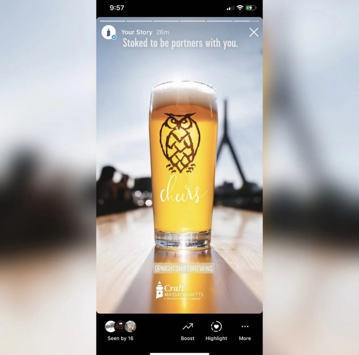 A photo of a tall glass of beer with a foam head, featuring an owl logo and the word 'cheers' written on it. The background appears to be an outdoor setting with the sky and a structure visible. The image includes text indicating it's from a social m