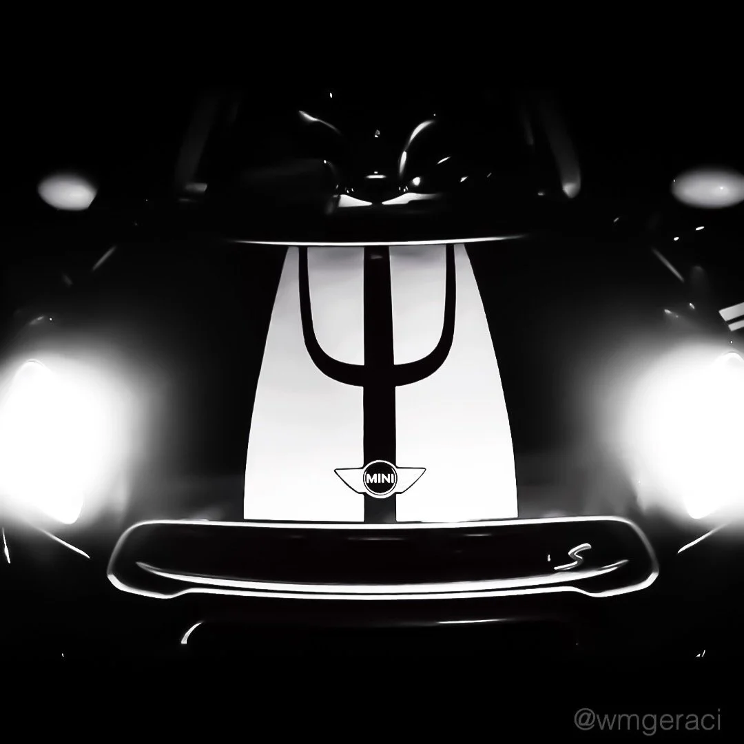 Black Mini Cooper with blue racing stripes and a Greek letter psi symbol on the hood.