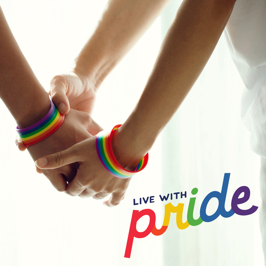 Two people holding hands, each wearing rainbow pride bracelets, with the text "Live with pride" in rainbow colors.