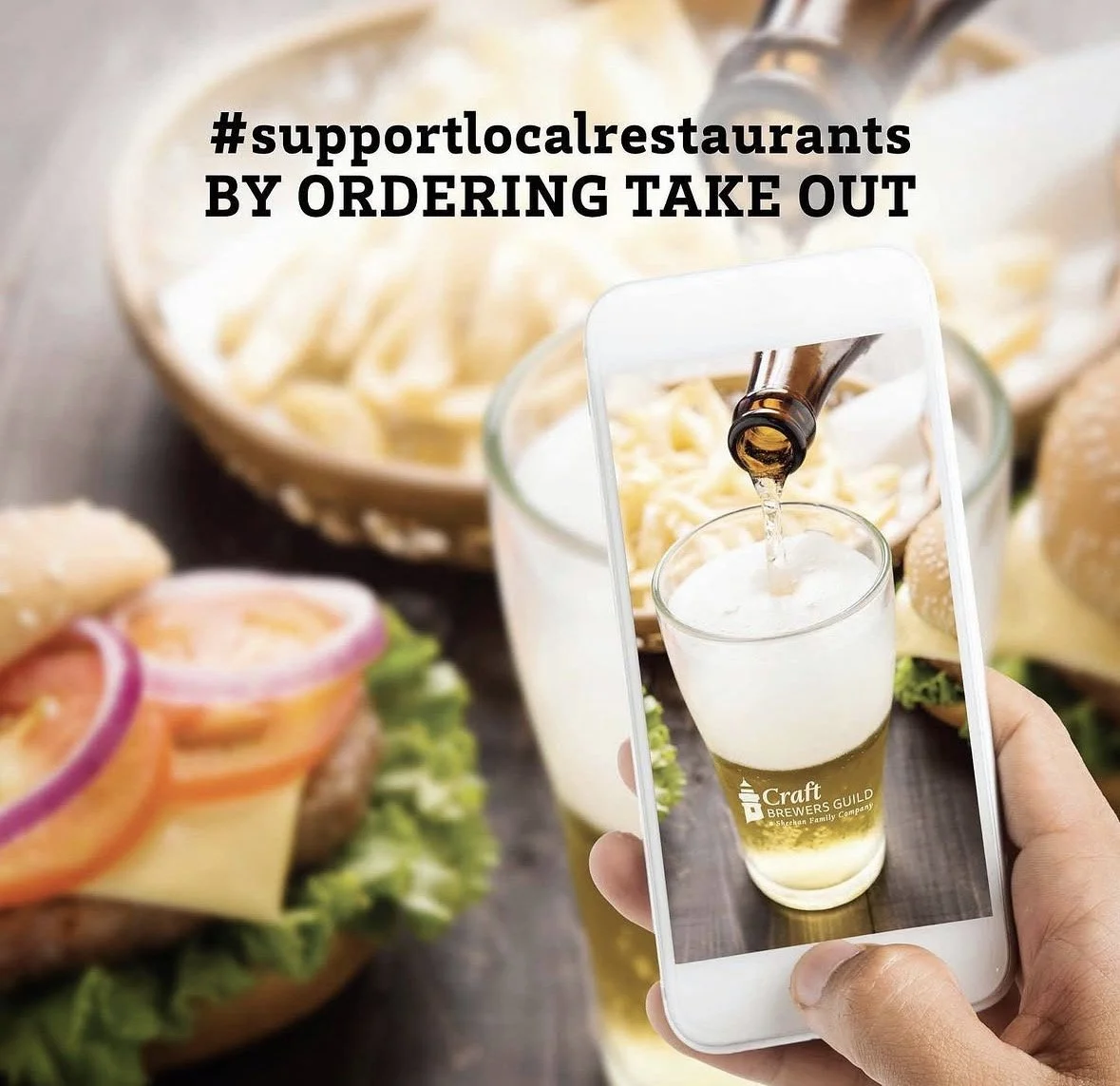 A person taking a photo of a beer being poured into a glass using a smartphone. The background shows a burger and other food items. Text overlay reads '#supportlocalrestaurants BY ORDERING TAKE OUT'.