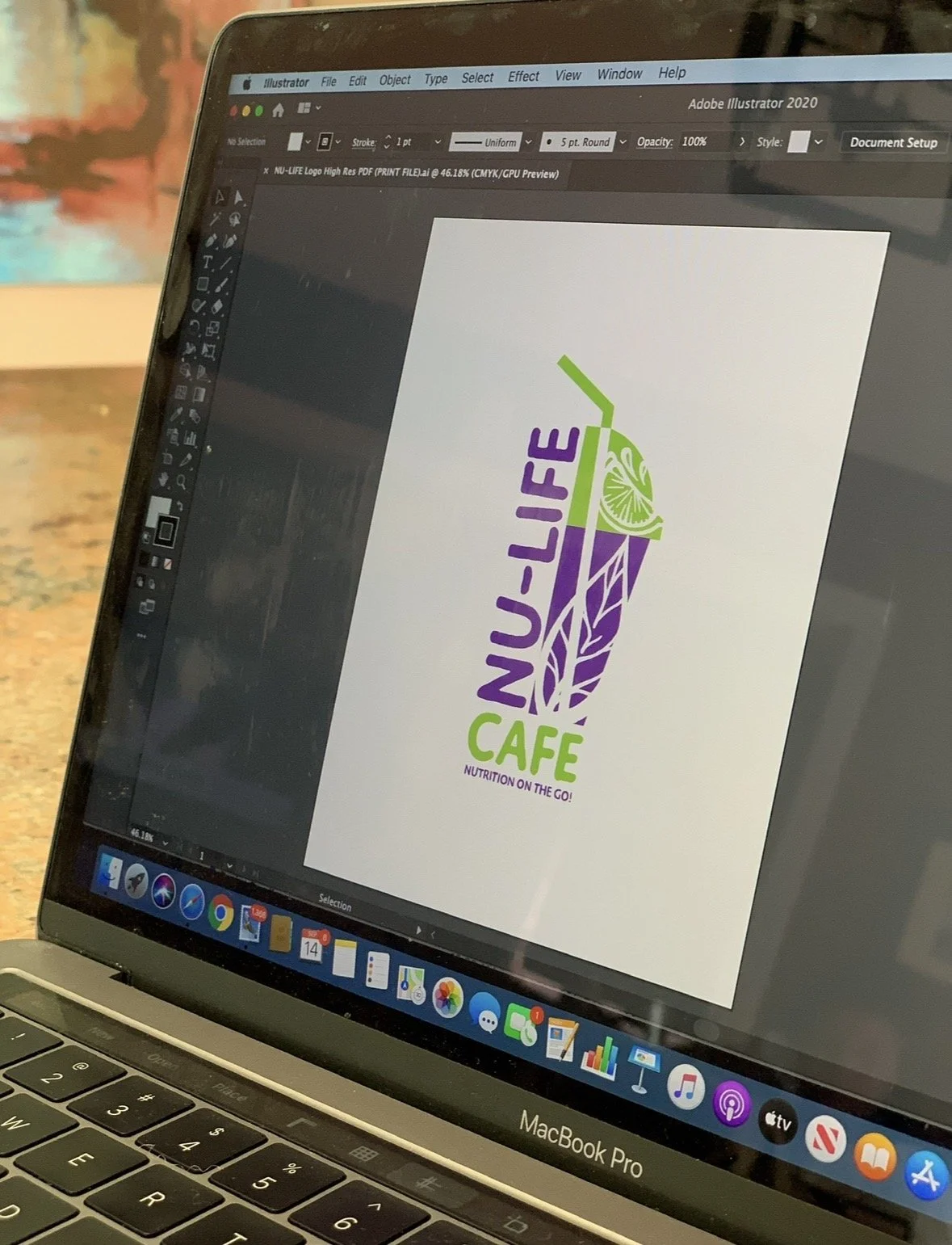 Design of a logo for Nu-Life Café on a computer screen in Adobe Illustrator, featuring a stylized drink with a straw, leaf, and citrus slice, with the text "NU-LIFE CAFE" and the tagline "NUTRITION ON THE GO!"