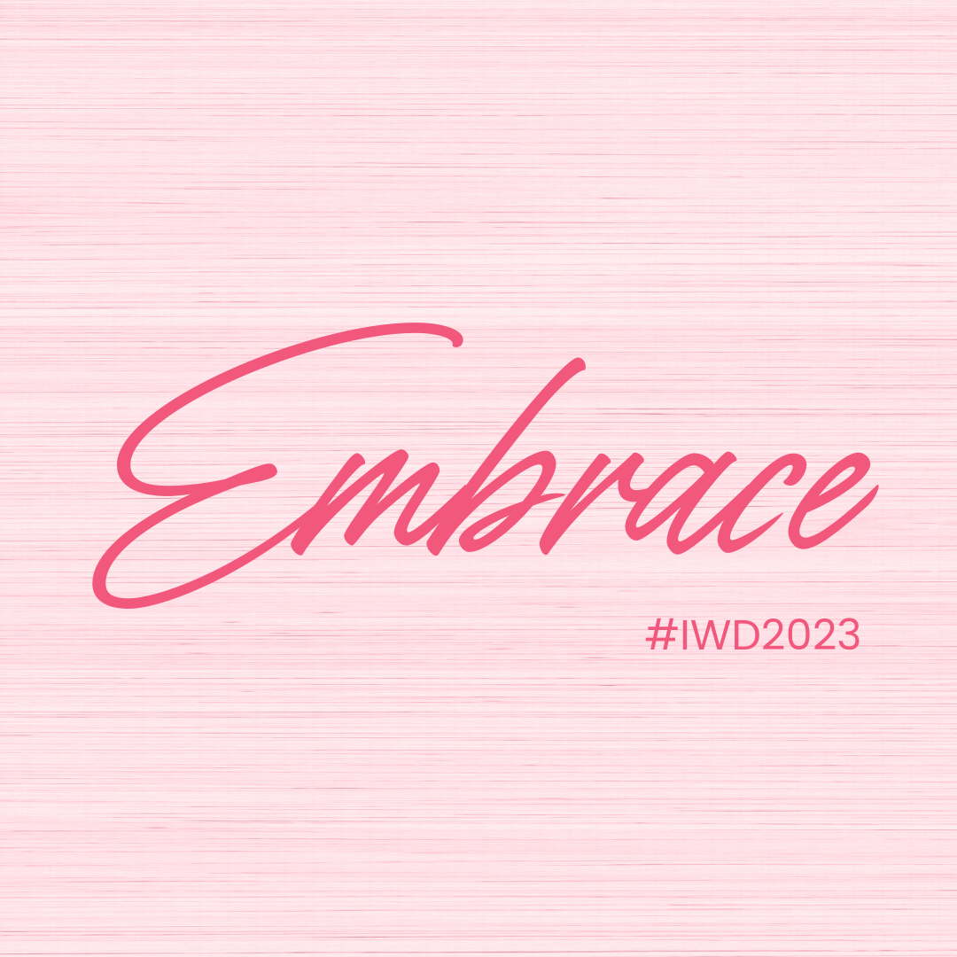 Pink background with the word 'Embrace' written in cursive and pink shades, along with the hashtag '#IWD2023' indicating International Women's Day 2023.