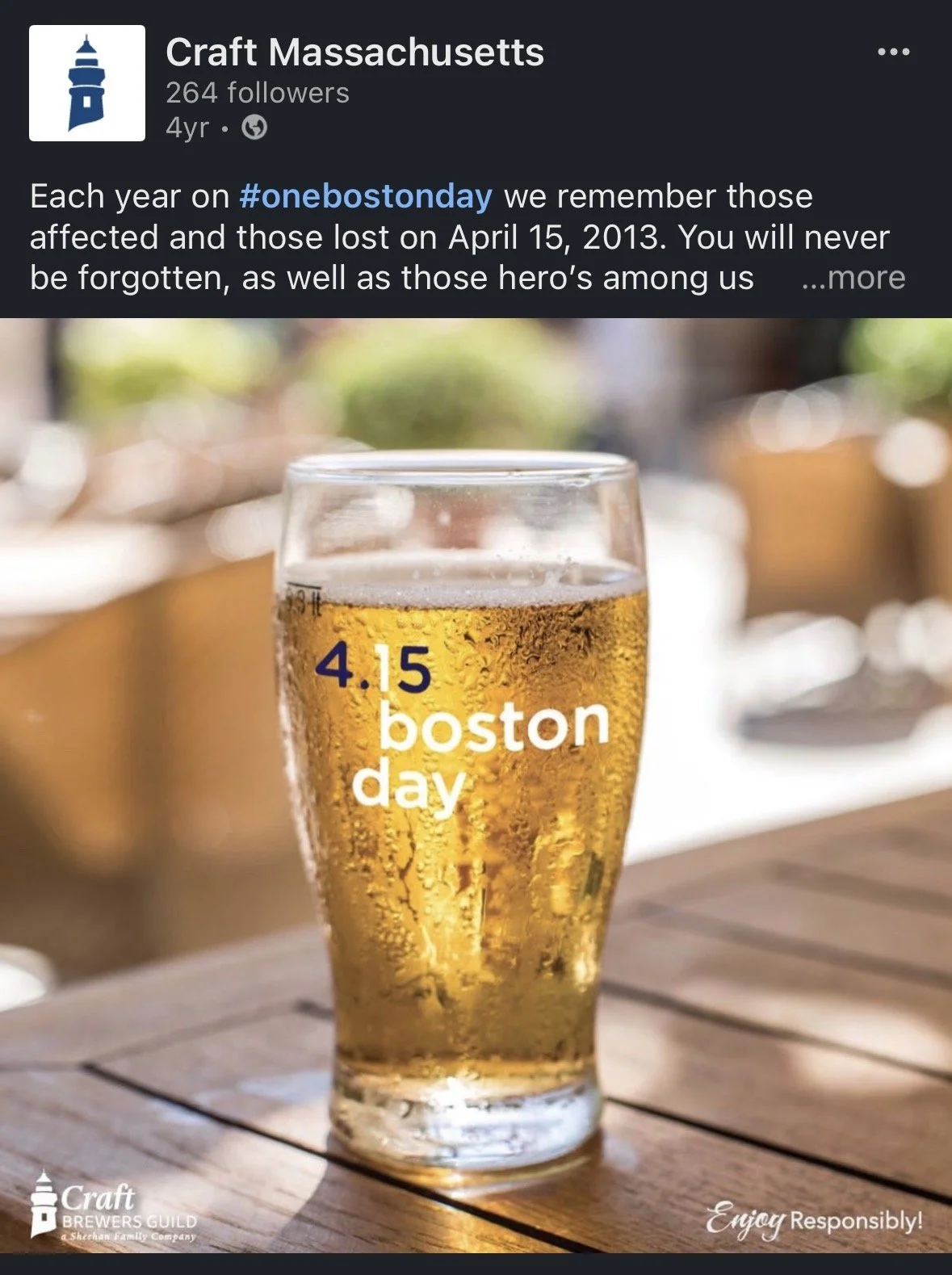 A glass of beer on a wooden table with the text '4.15 Boston day' overlaid on it.