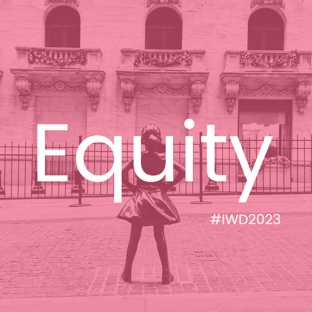 A statue of a girl with her hands on her hips, standing in front of a building with ornate balconies, overlaid with pink color and the word 'Equality' and hashtag '#IWD2023'.