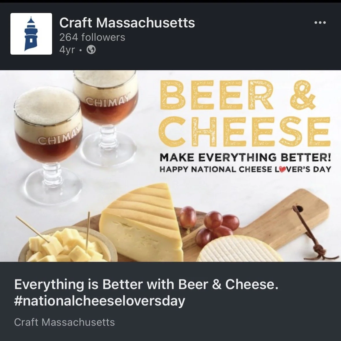 Two glasses of beer with foam on top, slices of cheese on a wooden board, and bunches of grapes on a white surface celebrating National Cheese Lover's Day.