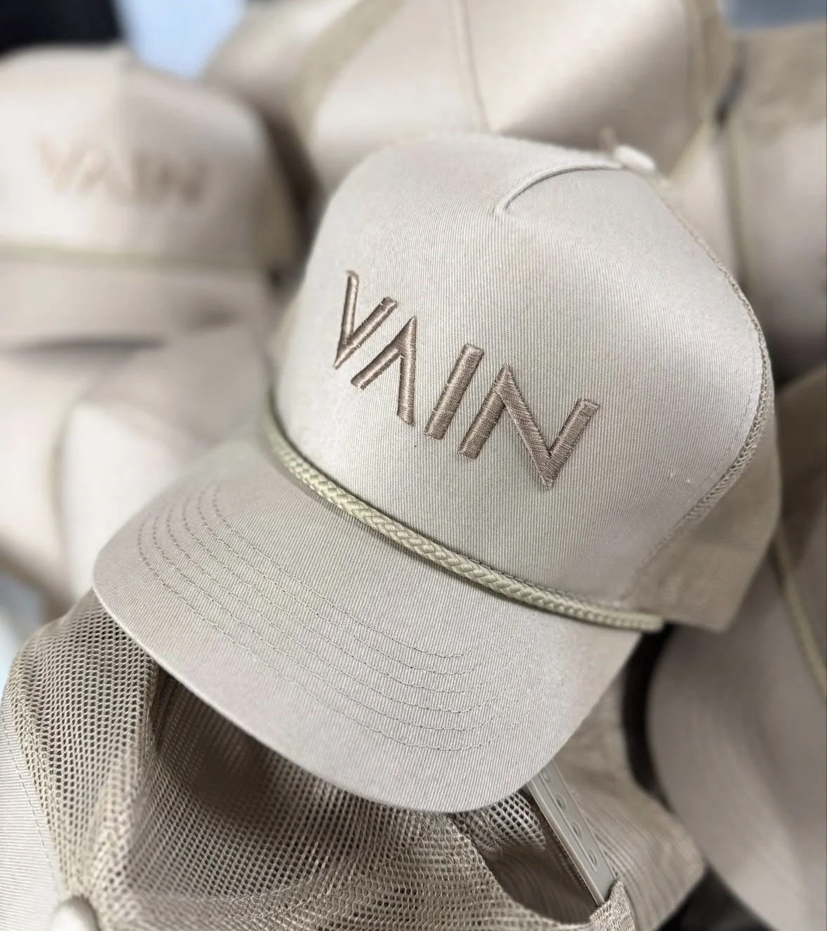 A beige baseball cap with the name 'VANIN' embroidered on the front.