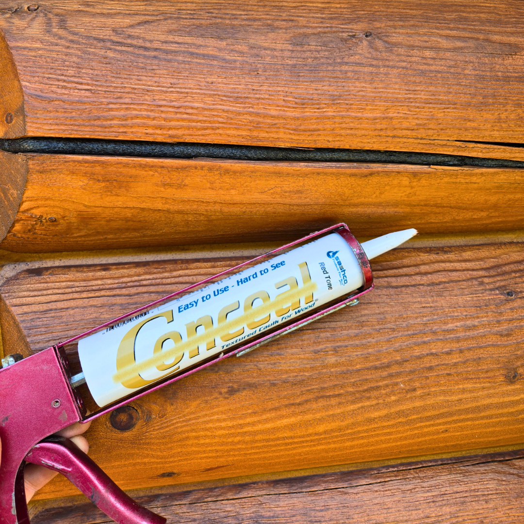 A caulking gun applying sealant to wooden planks on a deck.
