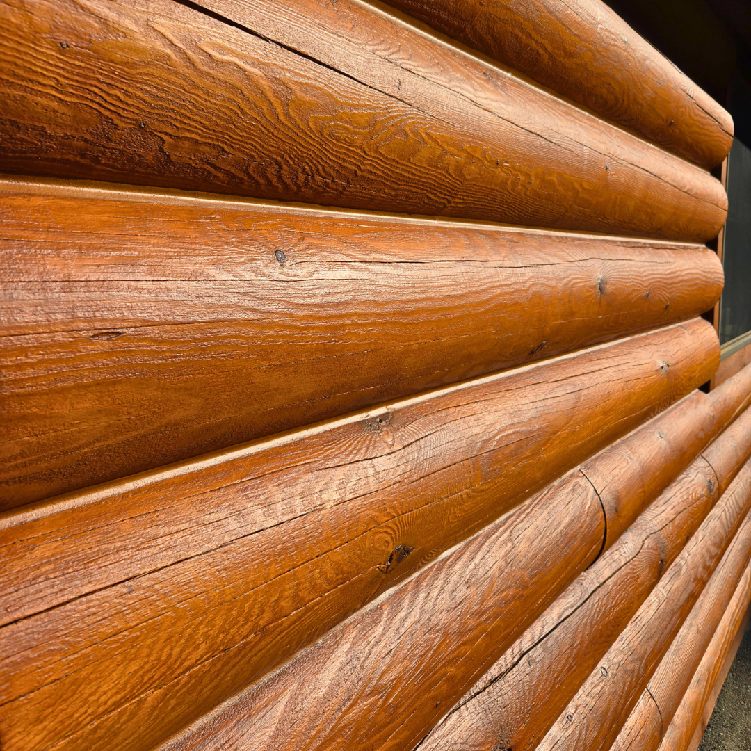 Close-up of horizontal wooden logs with a polished, reddish-brown finish.