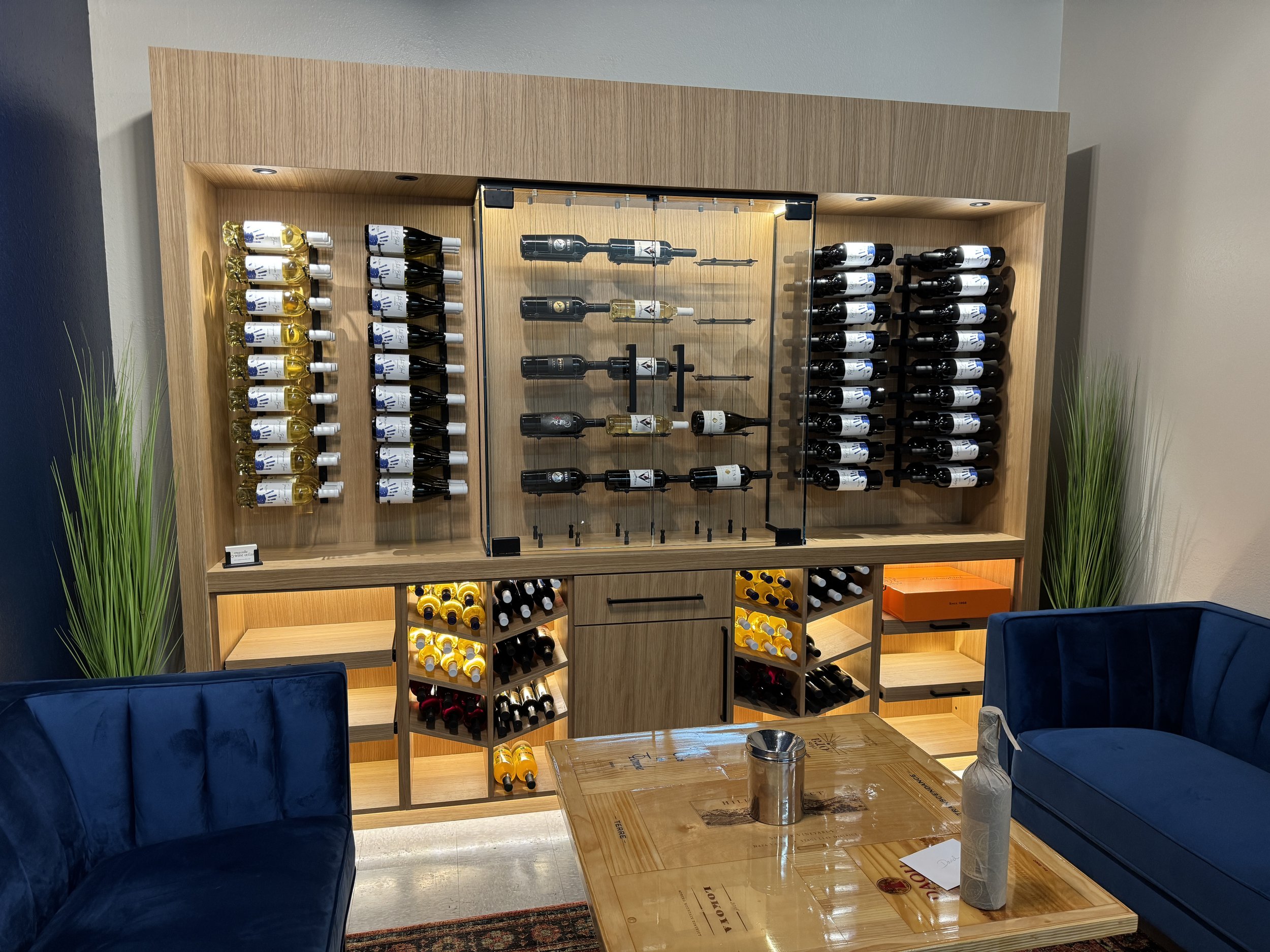 Custom wine wall with a tasting case and seating, built for a hospitality space.