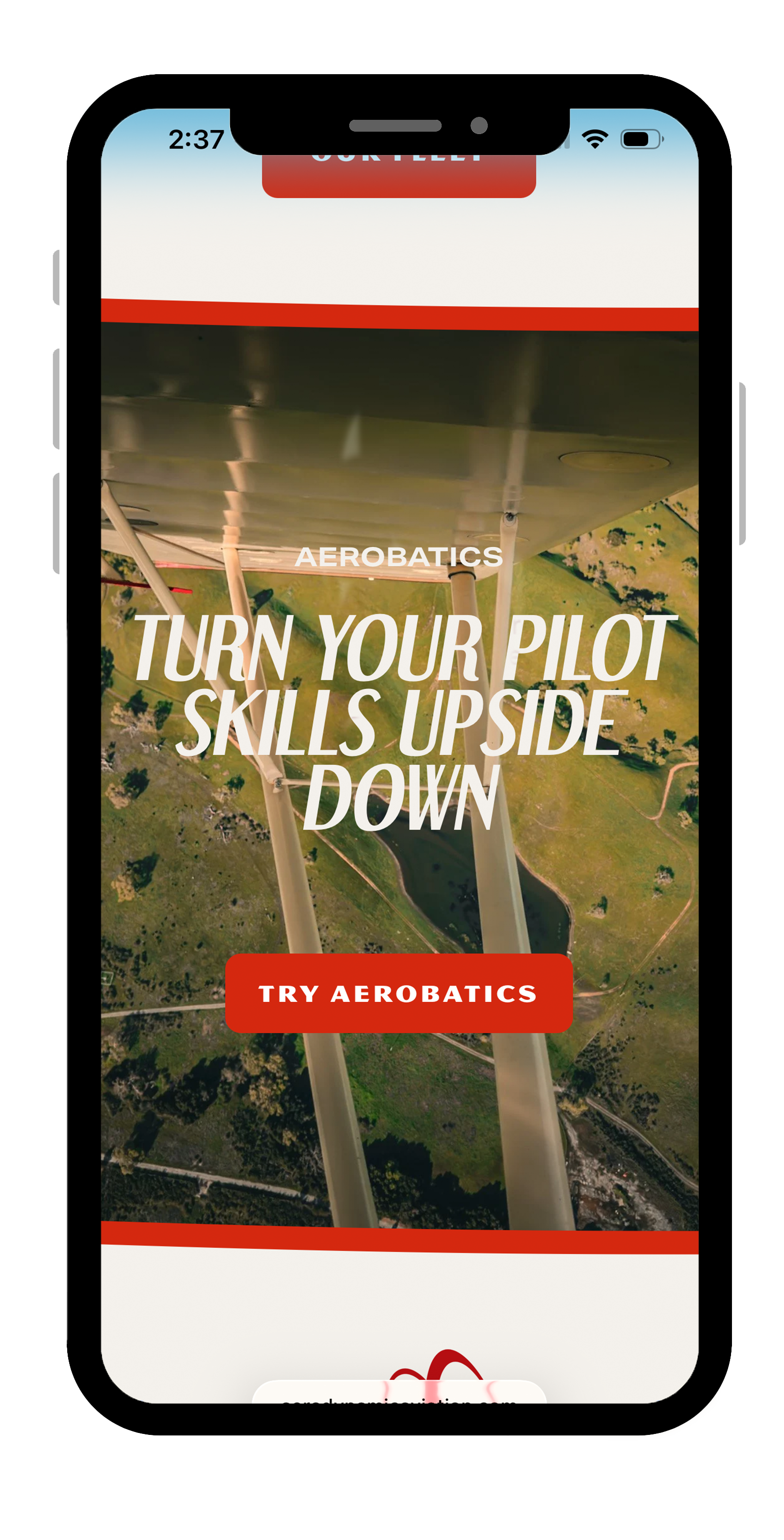 Mobile phone screen displaying an aerobatics app with a background image of an airplane wing and landscape below, featuring the instruction 'Turn your pilot skills upside down' and a red button labeled 'Try Aerobatics'.