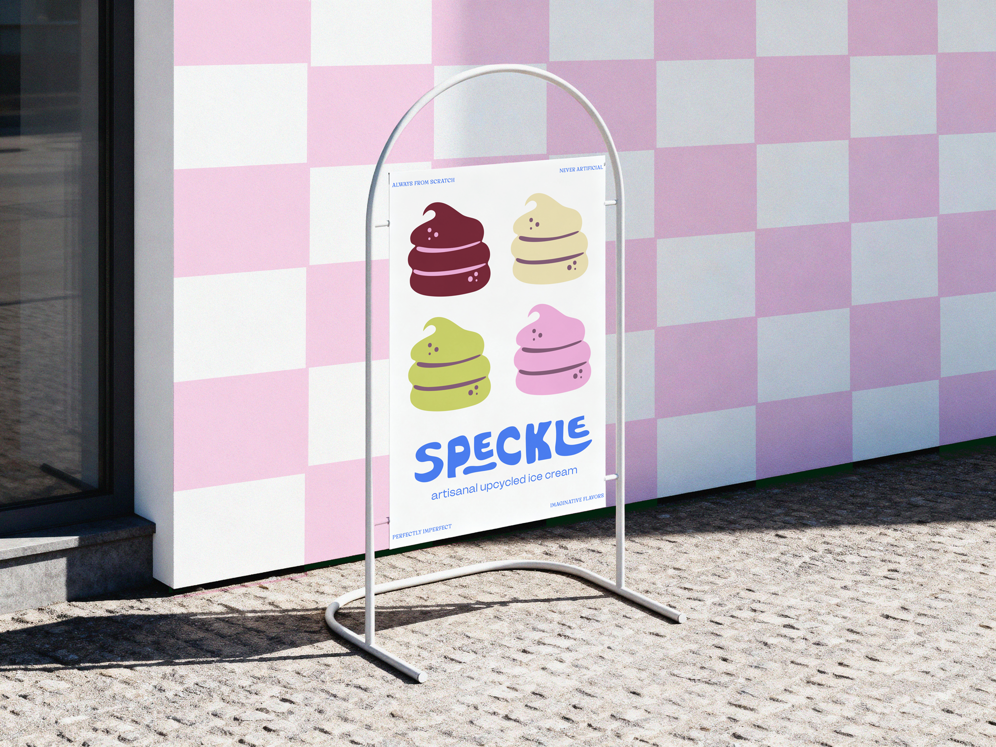 Sign advertising ice cream called 'Speckle' with colorful, stylized illustrations of soft serve ice cream cones in shades of purple, yellow, and pink, outside a pink and white checkered building.