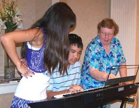 Nancy Forry shows Hartman grandchildren Julianna and Stephen-Alexander the great keyboard effects you can get just by pushing a button!