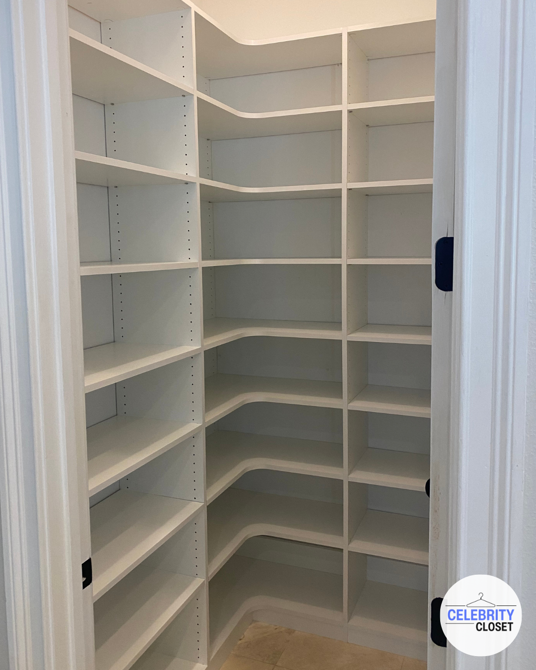 Empty white corner pantry with multiple shelves in a home