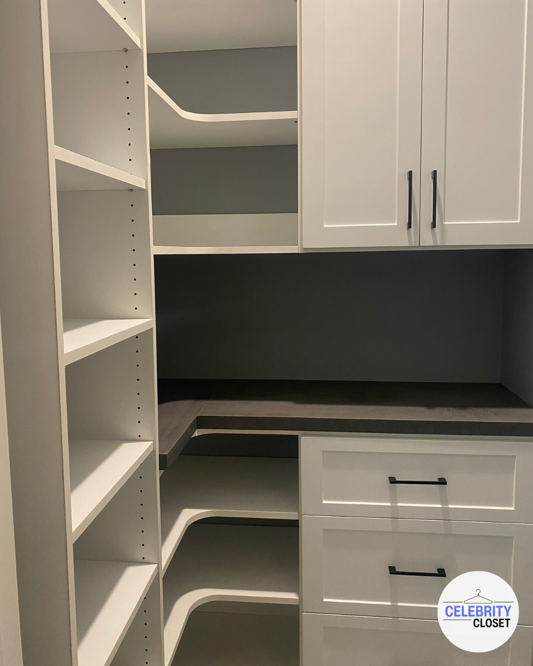 White custom closet with open shelves on the left, drawers and cabinets on the right, and a dark countertop in the middle, branded with Celebrity Closet logo at the bottom right.