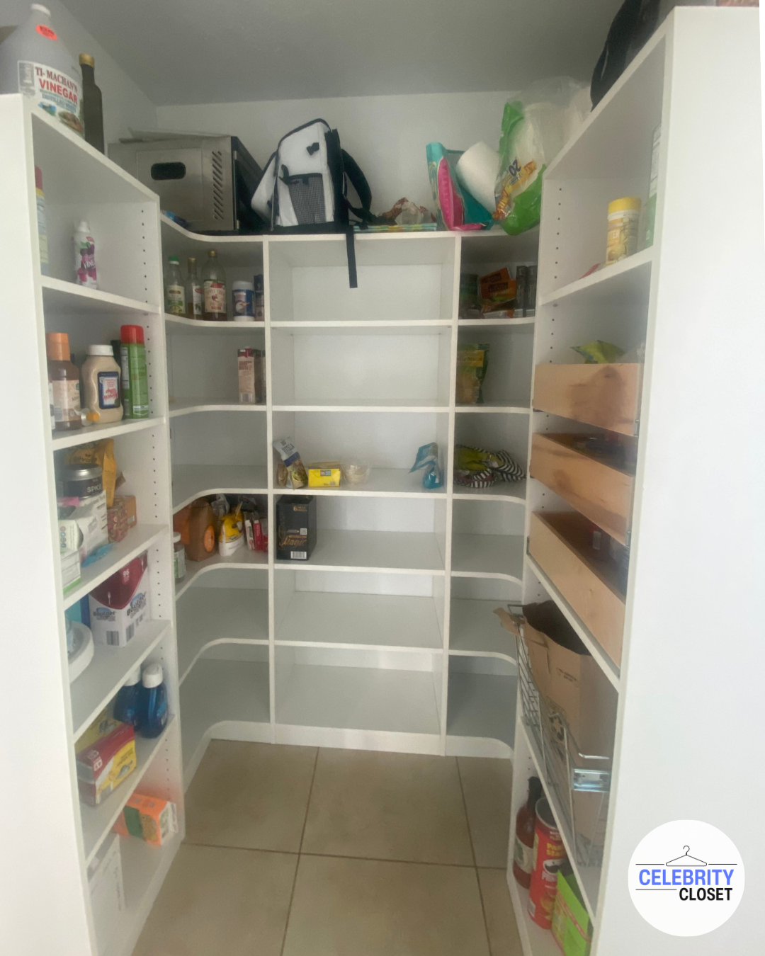 Empty white pantry shelves with some food and kitchen items on top and few items on the shelves, including condiments, snacks, and cleaning products.