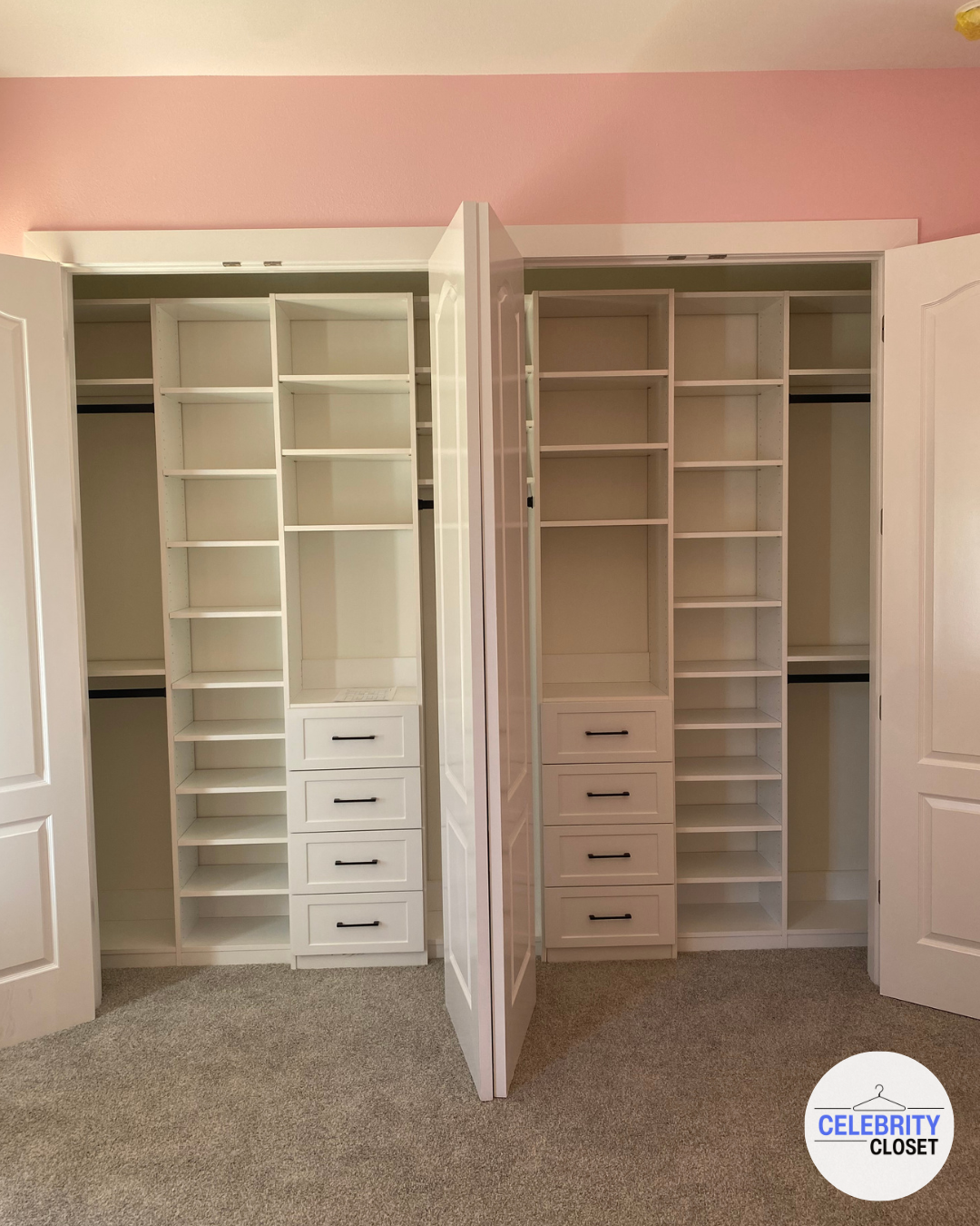 Two white open closet systems with multiple shelves and drawers, empty, in a room with pink walls and beige carpet, with a logo that says 'Celebrity Closet' in the bottom right corner.