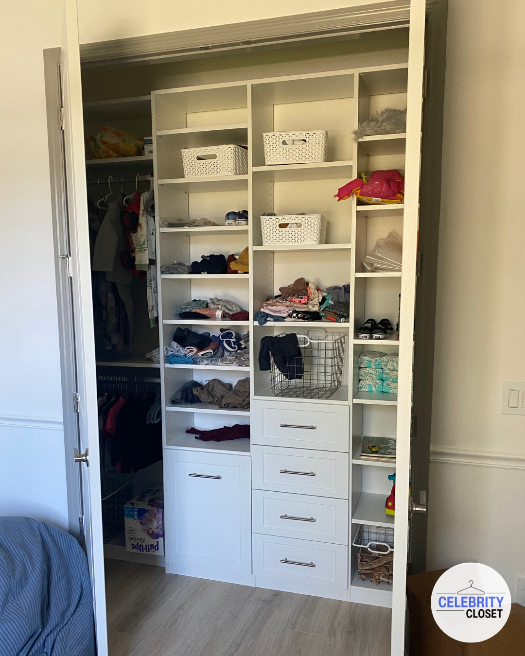 Open closet with shelves, drawers, and hanging space containing folded clothes, shoes, and storage baskets.